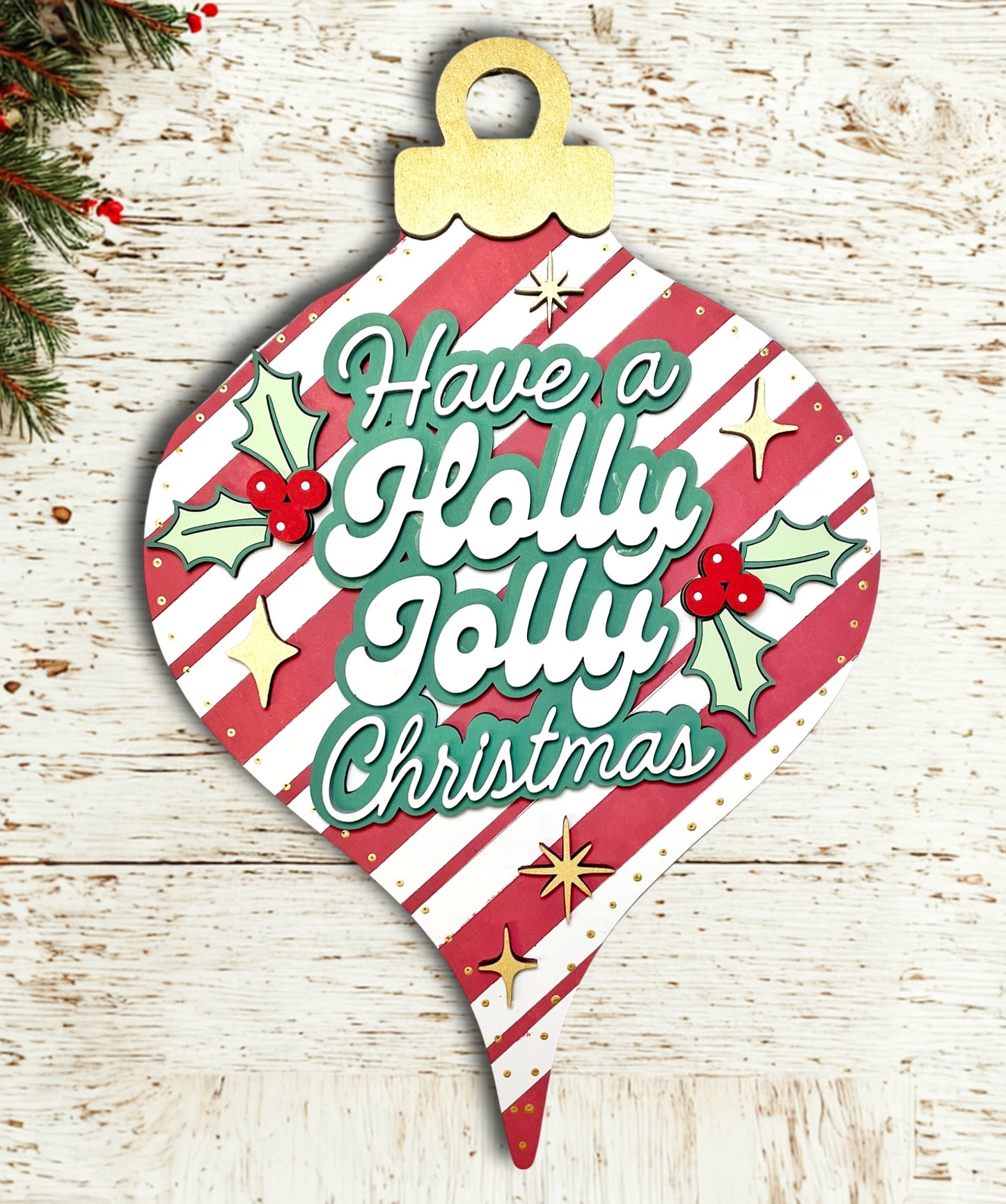 Decorative Christmas ornament shaped sign with 'Have a Holly Jolly Christmas' text on a wooden background.