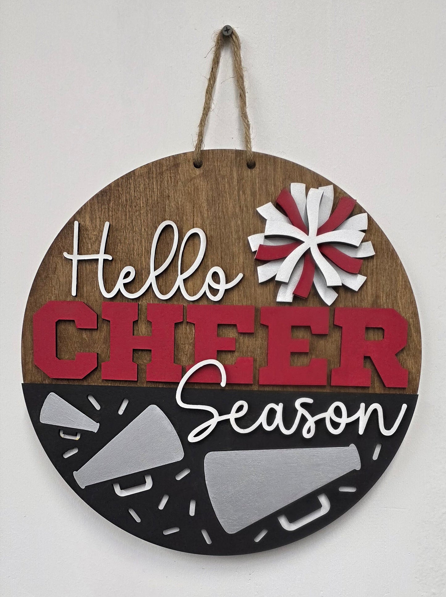 Round wooden sign with 'Hello Cheer Season' text and festive designs on a white background