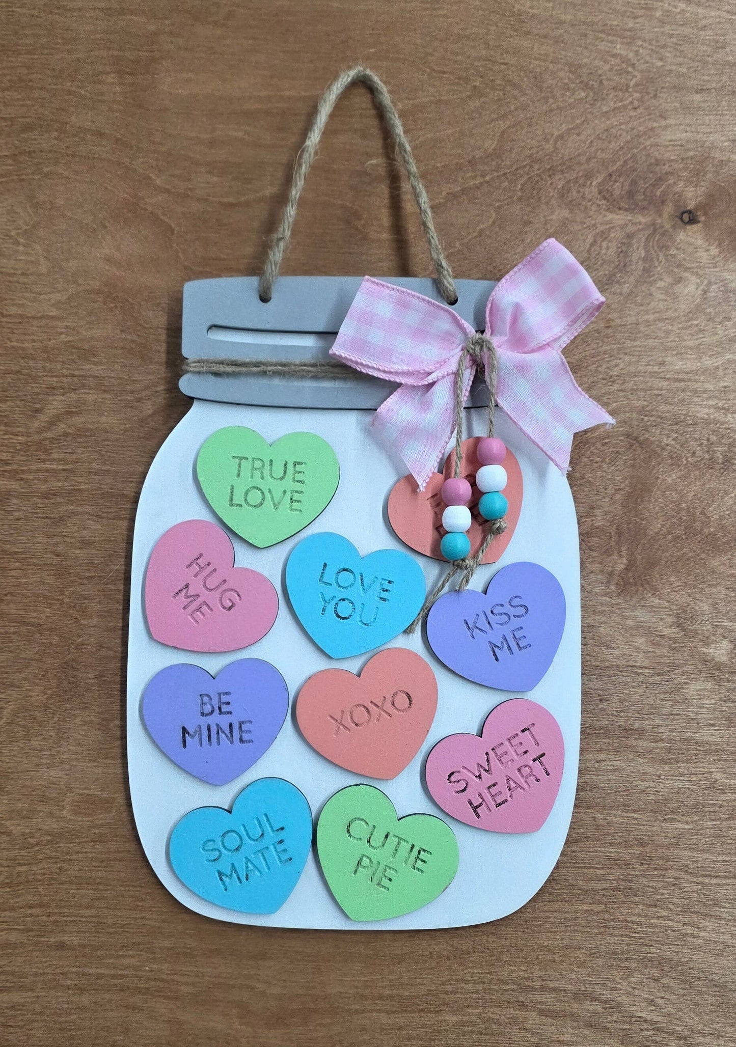 Decorative card shaped like a mason jar with colorful candy hearts on a wooden surface