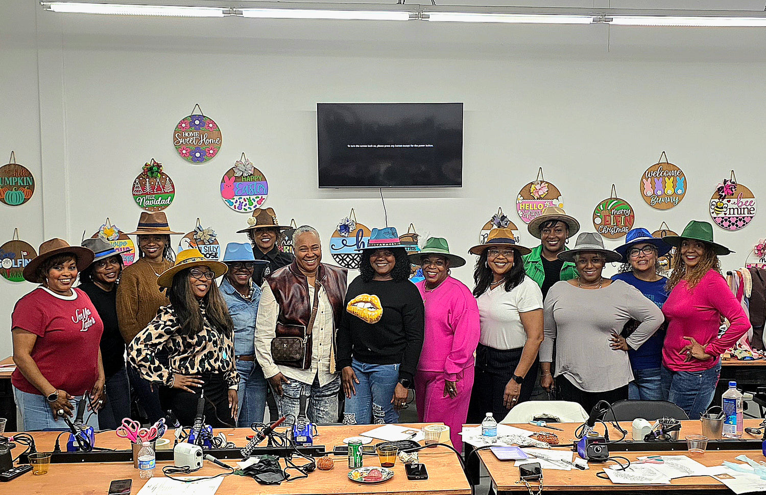 Group of people wearing festive hats in a room with decorations and a TV.