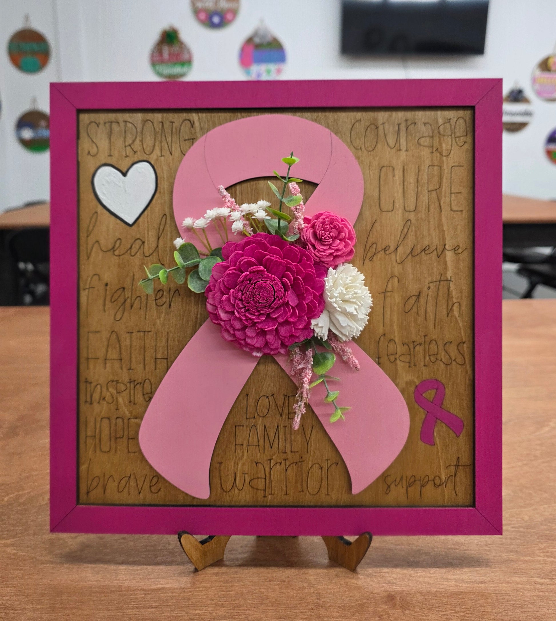 Decorative wall art with pink bow and flowers on a wooden background