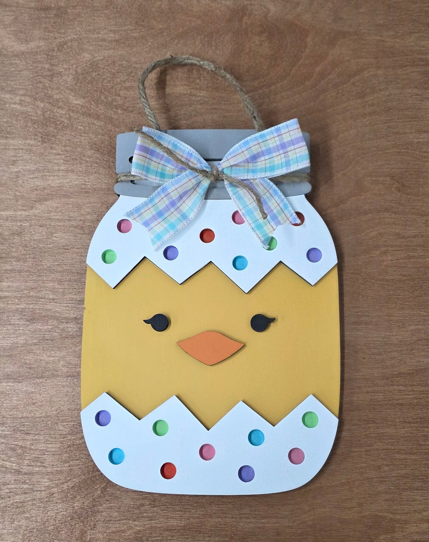 Decorative Easter sign ornament with a bow on a wooden surface