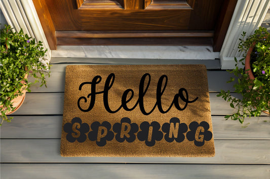 Doormat with 'Hello Spring' text on a wooden porch