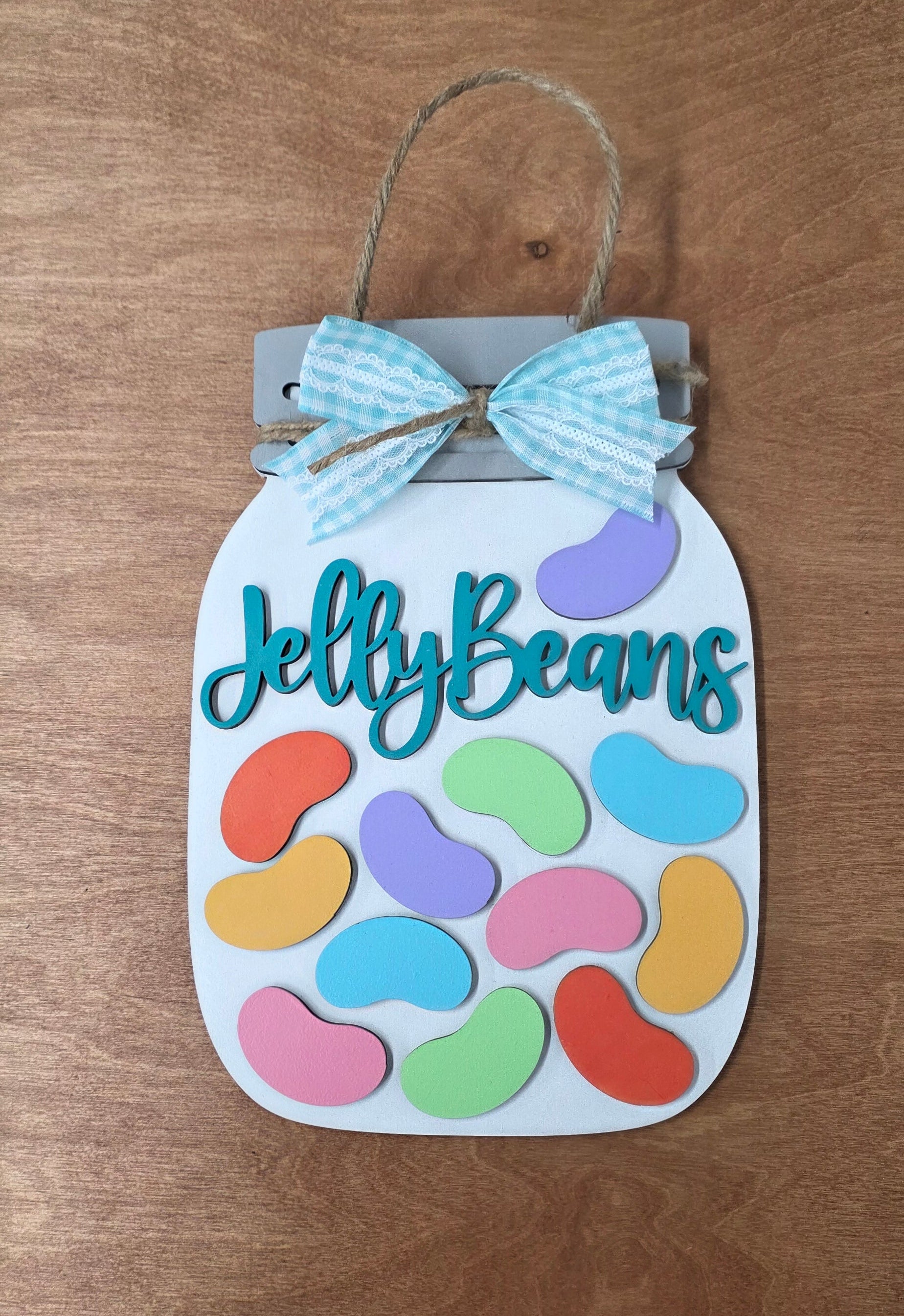 Decorative sign with colorful jelly bean design and 'Jelly Beans' text on a wooden surface.