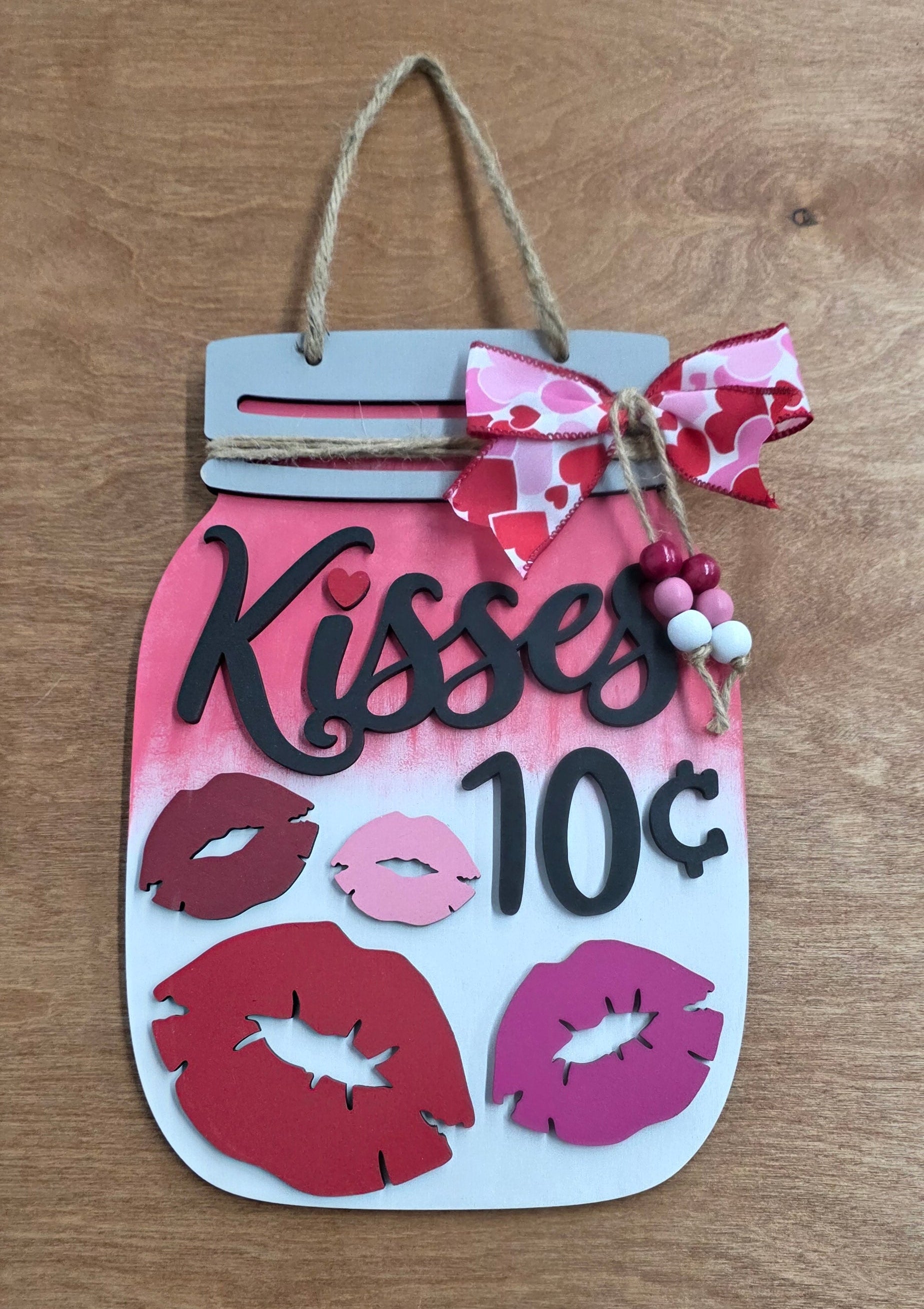 Decorative sign with lip prints and text on a wooden surface