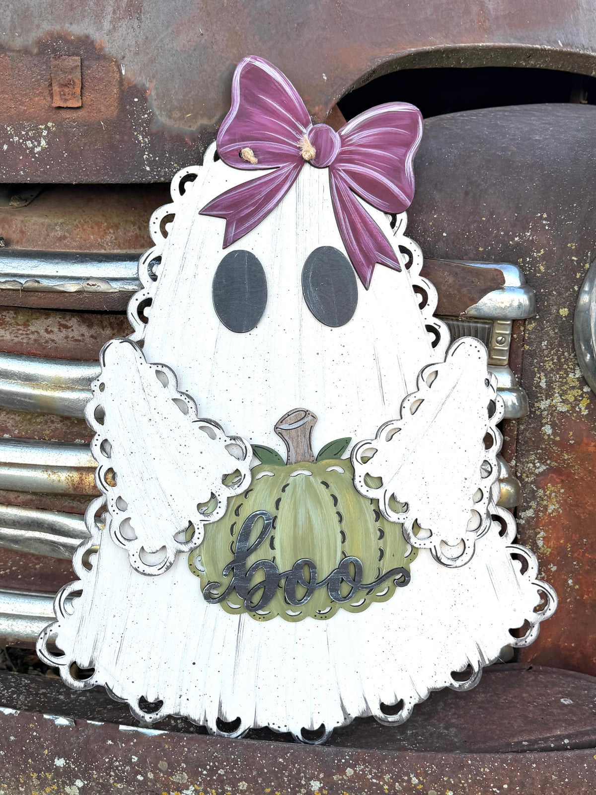 Wood Lace ghost with bow on top and holding a wooden painted pumpkin.