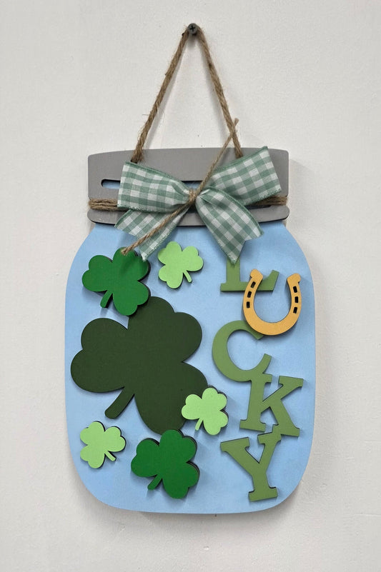 Decorative sign with shamrock designs on a light blue background