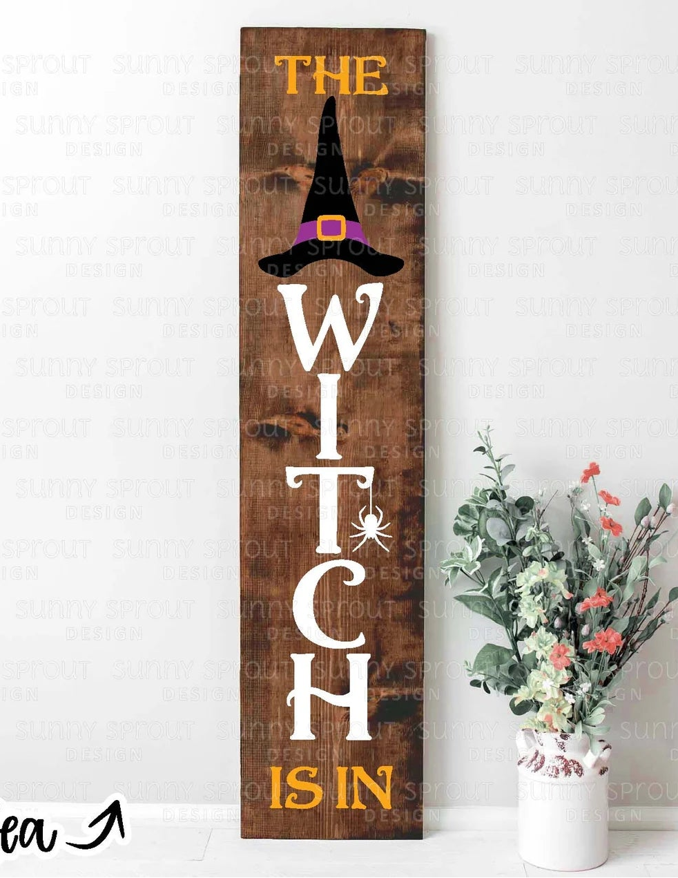 Wooden Halloween sign with 'The Witch is In' text and a vase of flowers on a white background