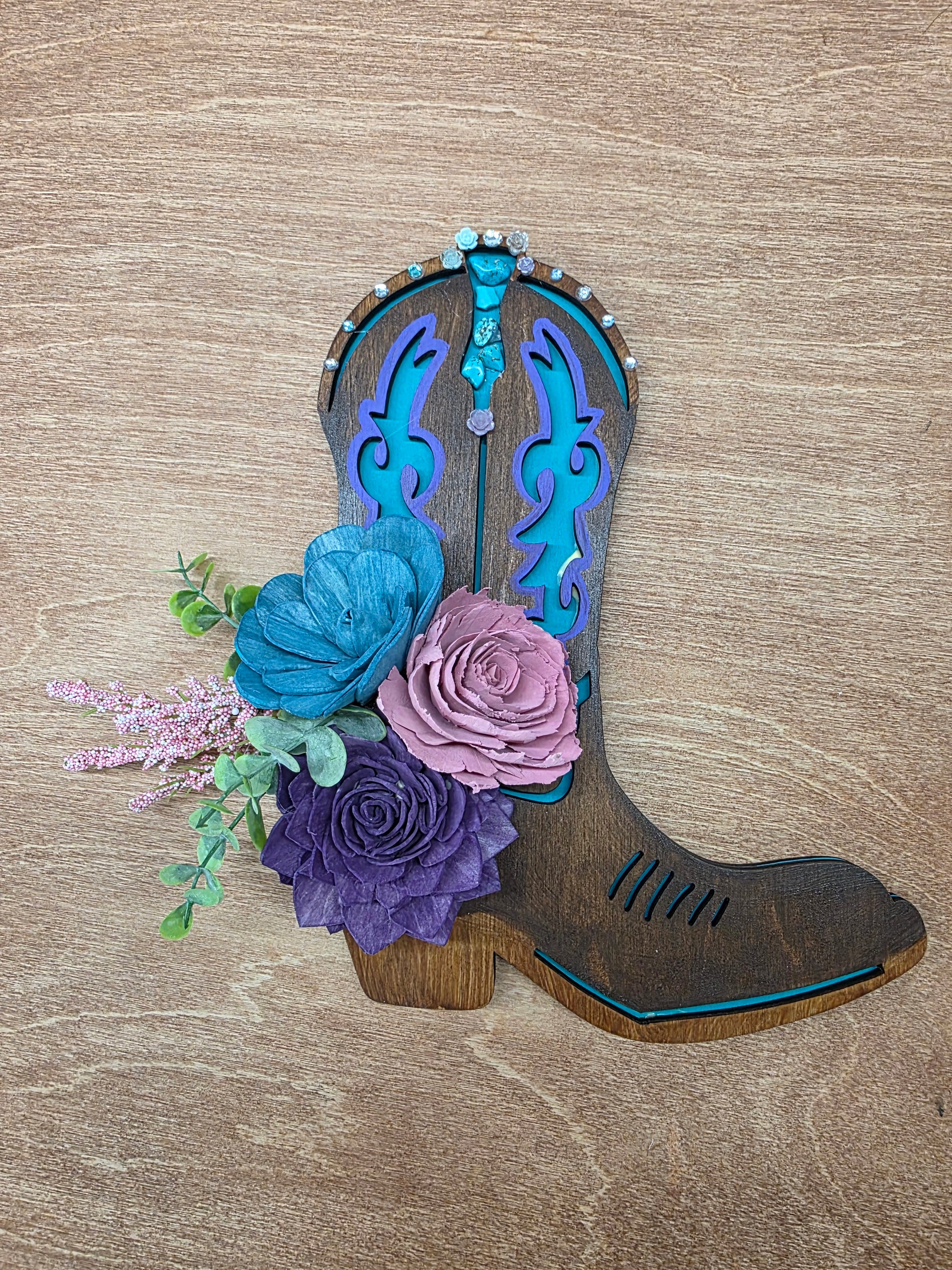 Decorative boot with flowers on a wooden surface
