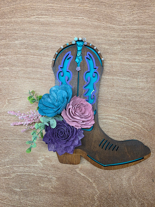 Decorative boot with flowers on a wooden surface